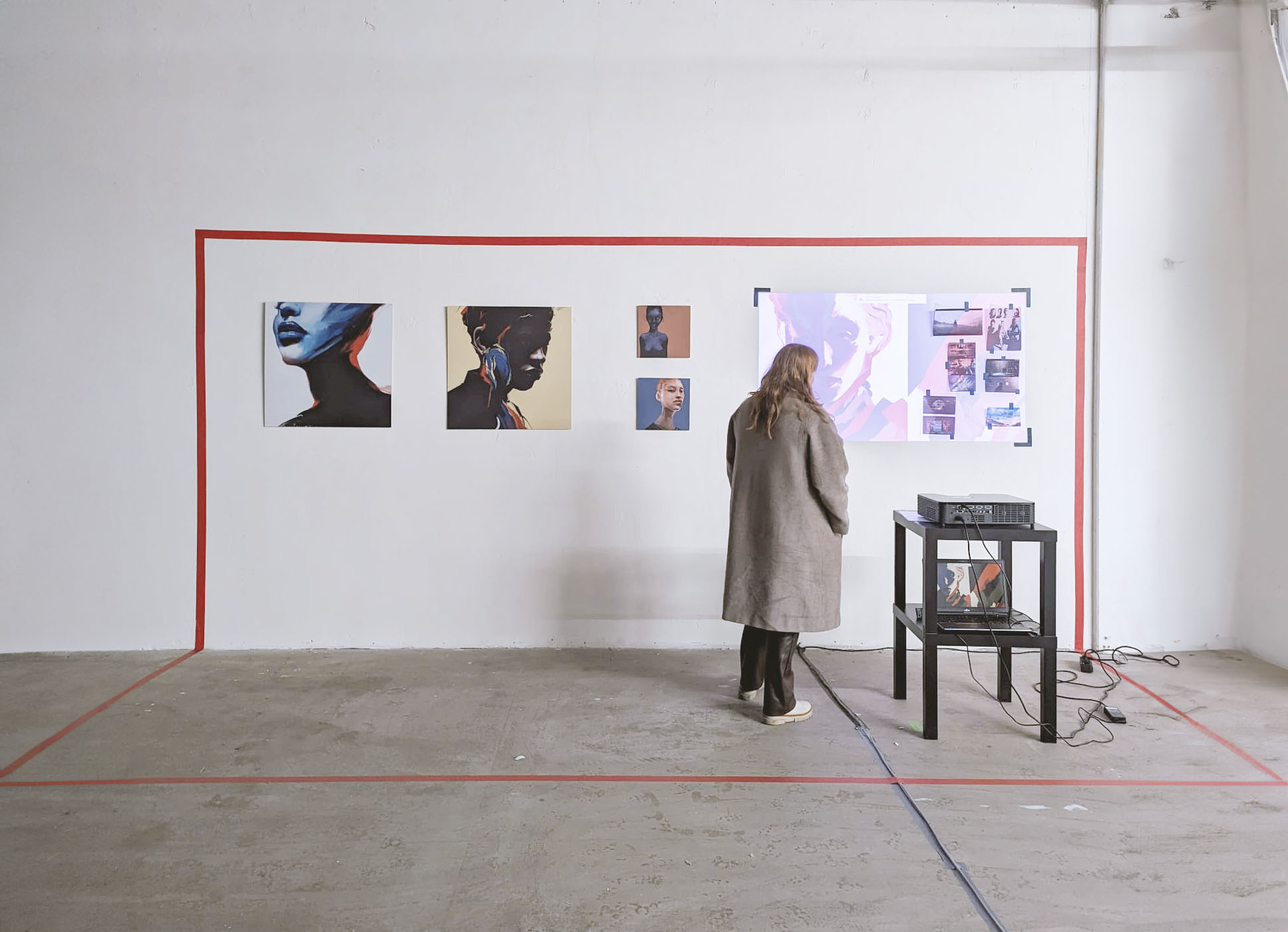 Visitor viewing portraits and projected imagery in an exhibition space